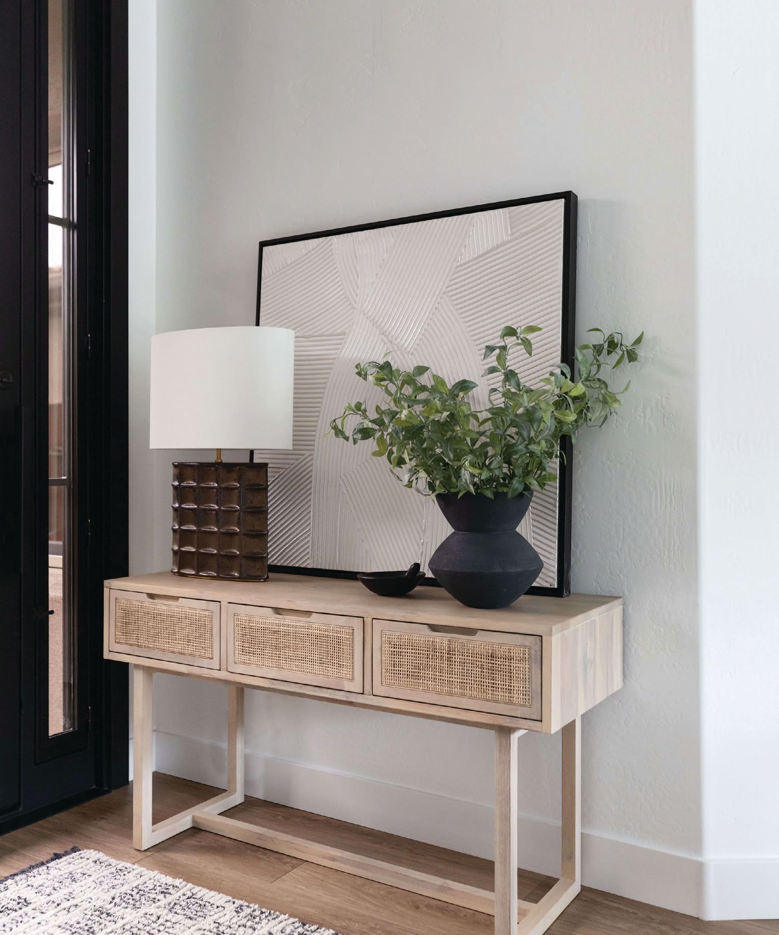 Four Hands’ Clarita console table and the Struttura medium table lamp from Visual Comfort greet guests in the entryway. Photographed by Life Created