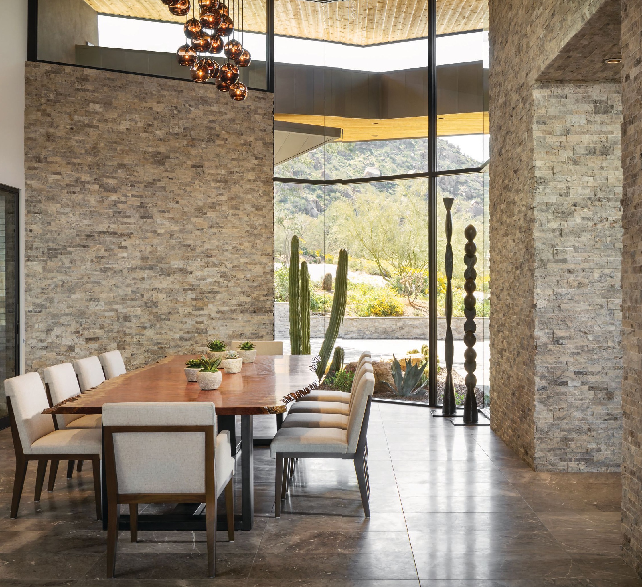 While the exterior of the home is more extreme architecturally, inside, an abundance of natural stone creates warmth and provides a feeling of protection from the outdoors. “The dining room is enveloped with stone so it has a really amazing grounded sense,” Drewett explains. PHOTOGRAPHED BY JEFF ZARUBA