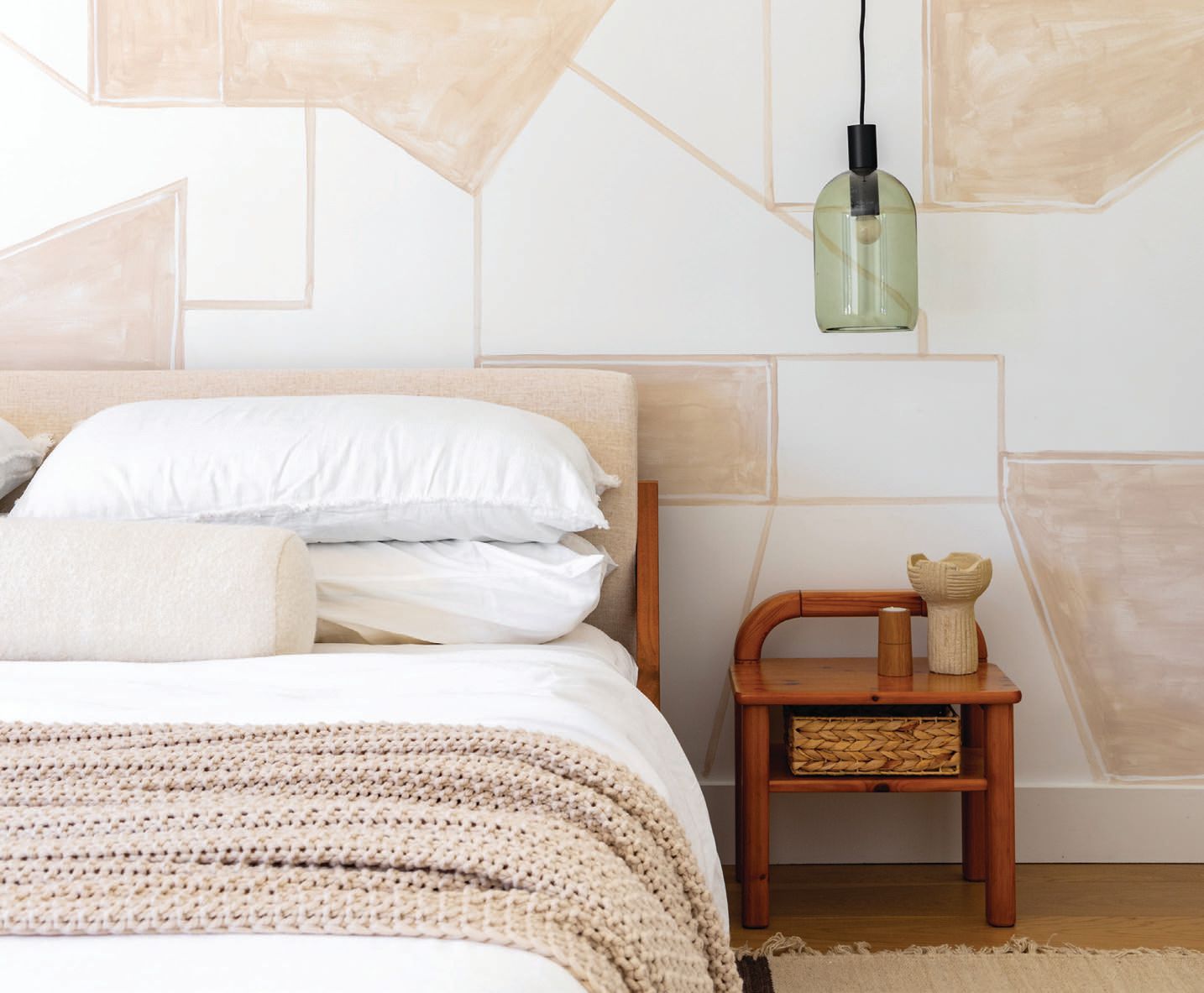 A painterly mural by Passion 4 Murals lights up the primary bedroom, which features a CB2 bed, a lumbar pillow from The Citizenry, vintage nightstands found at 1stDibs and Blu Dot pendant lights Photographed by Kevin Brost