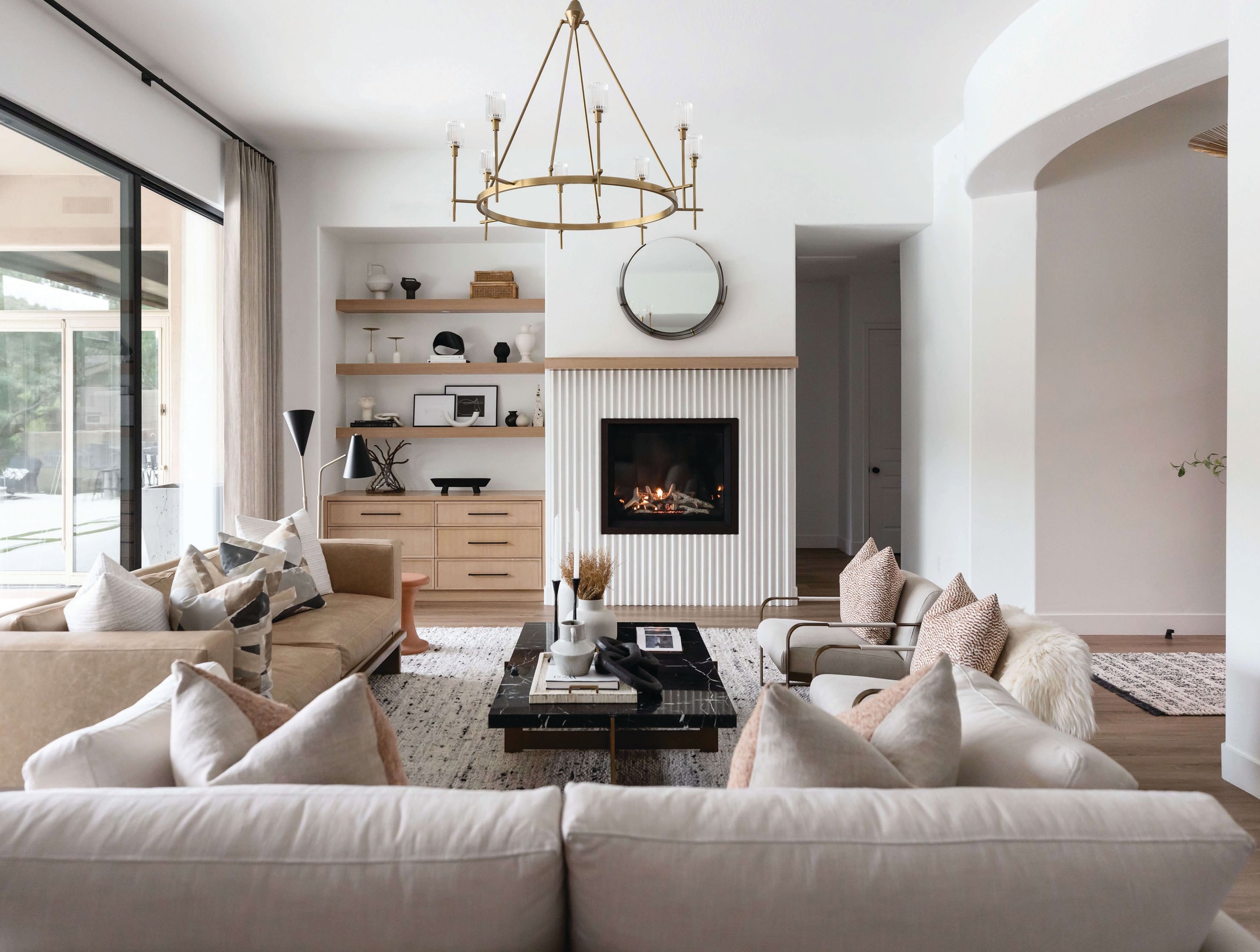 In this chic living room, Lauren Lerner from Living with Lolo included rift-cut white oak cabinets with floating shelves and a custom cement fluted fireplace as the focal point for the space. Photographed by Life Created
