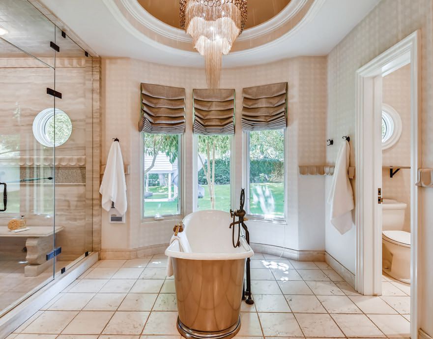 The drama of a domed ceiling and chandelier continues above the soaking tub in the primary bath. PHOTO BY VIRTUANCE REAL ESTATE PHOTOGRAPHY