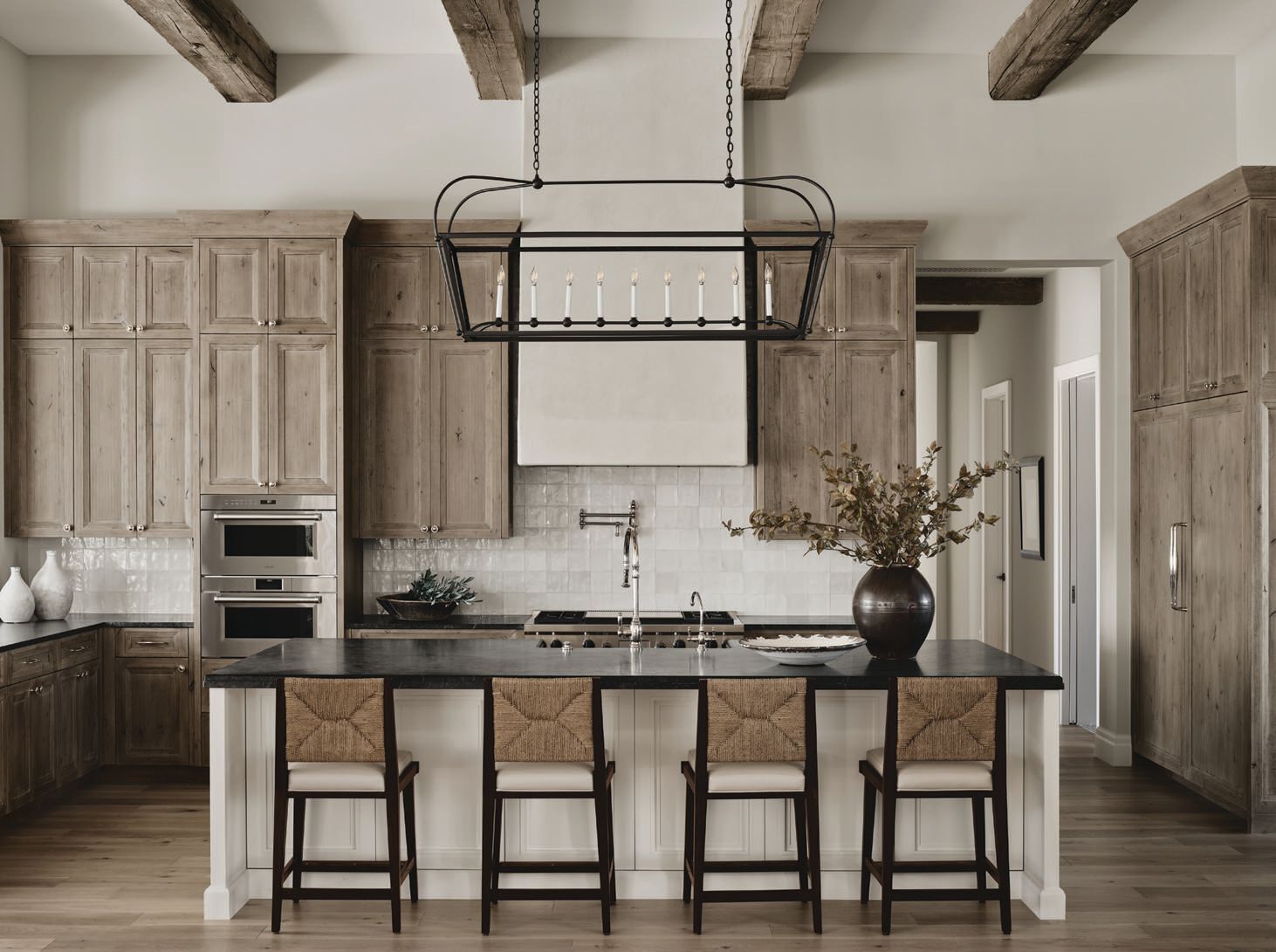Wood beams and cabinetry in a stained finish—with brass hardware from Clyde Hardware— add warmth to the kitchen. PHOTOGRAPHED BY DAN RYAN STUDIO