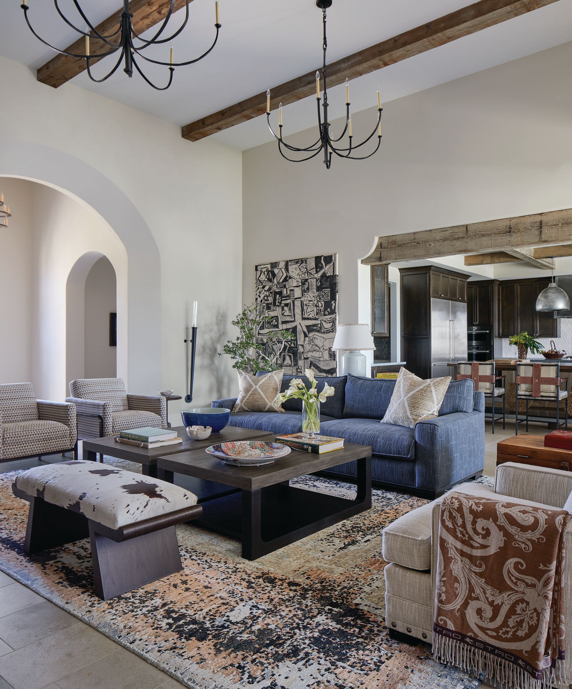 Soaring ceilings call for streamlined and statement-making chandeliers from Visual Comfort in the living room. A rug from Azadi grounds sofas from Lee Industries and Kravet, and tables by Robert James Collection and Allaire Inc. PHOTOGRAPHED BY LAURA MOSS