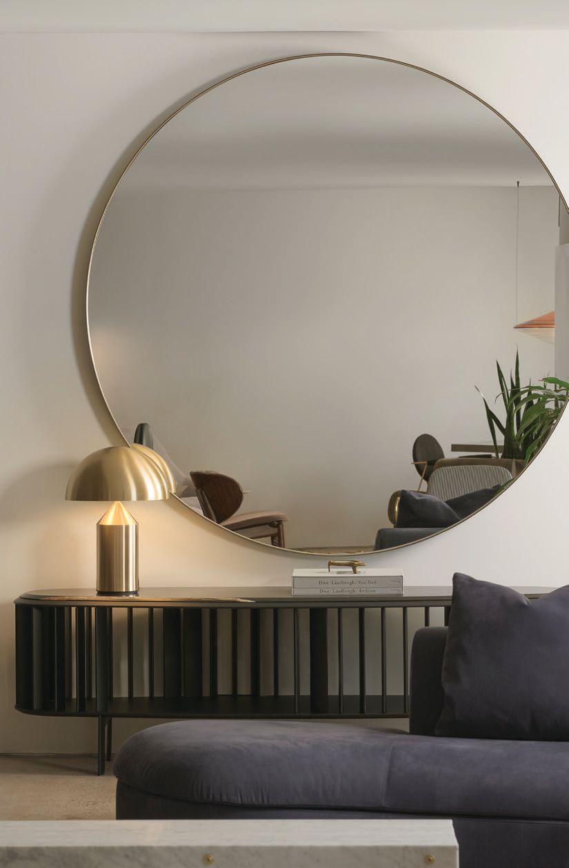 The Marlene mirror by Baxter draws the eye toward a vignette featuring a Living Divani Islands console and an Oluce Atollo lamp Photographed by Cole Horchler